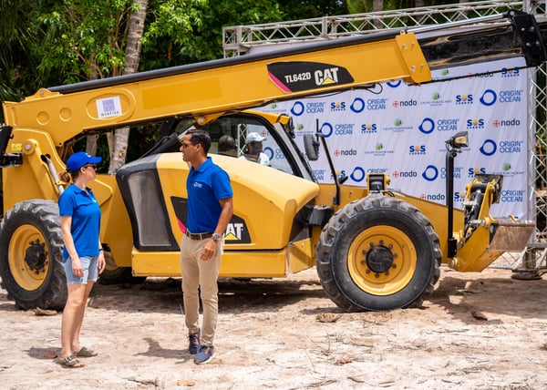 Partners discussing beside a heavy-duty CAT vehicle.